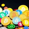 Monede criptografice diverse pe un fundal contrastant.